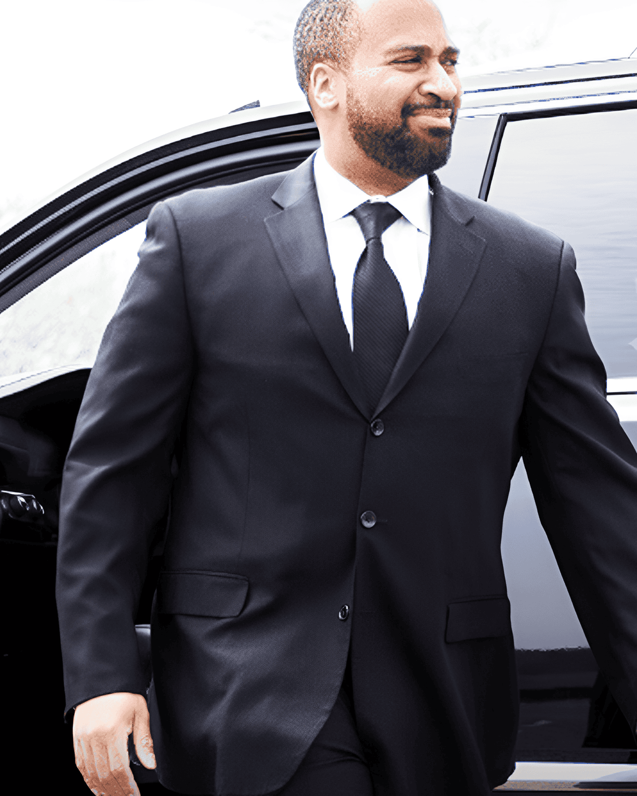 Man in a suit exiting a vehicle