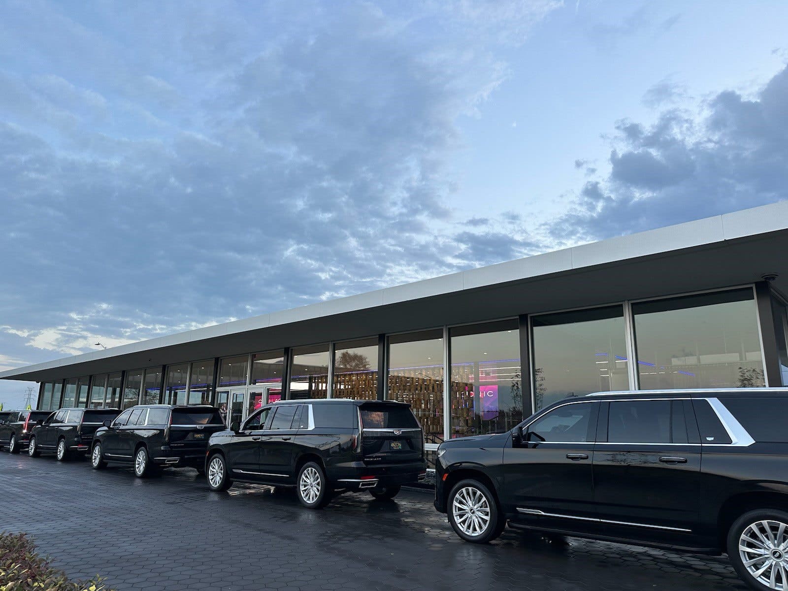 Row of luxury SUVs under cloudy sky